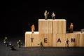 Miniature builders figure with wooden blocks with Ã¢â¬ÅTEAMÃ¢â¬Â wordings